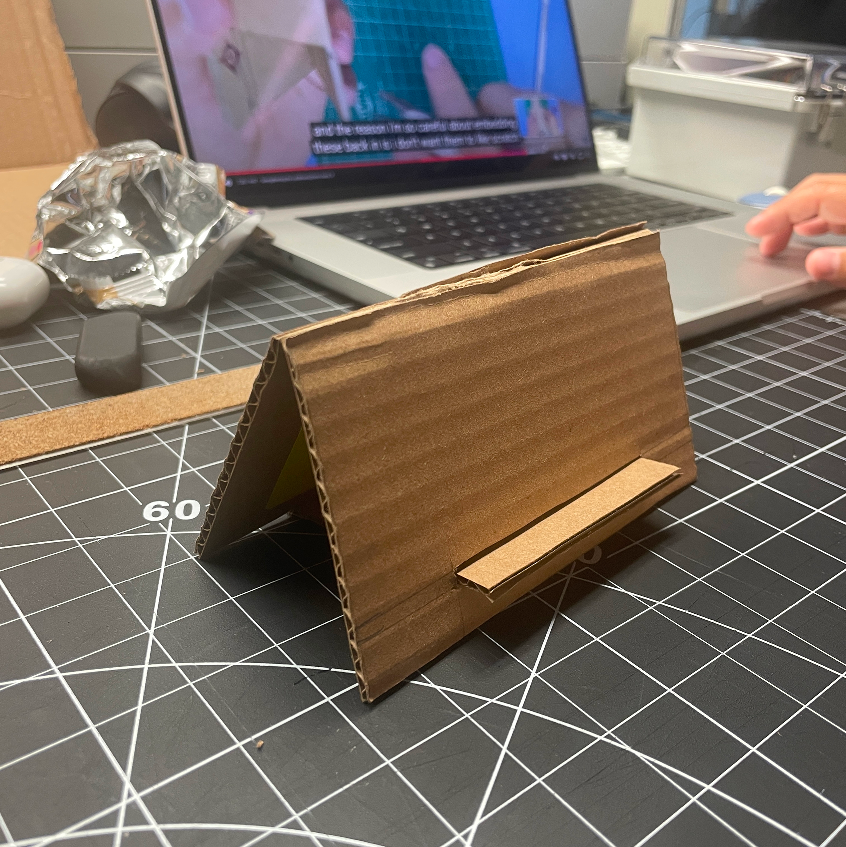 During week 7 we were given the task to create a geurilla prototype of an iPhone stand using one of the two tutorials provided in class. After completing the tutorial, we were also then asked to improve and make our own iteration of the stand based on how we could improve the original. This is an image of the final phone stand created by following the tutorial by Maker Brain.  <a href='https://www.youtube.com/watch?v=3LgJ7QjEKZs' target='_blank'><p>Link to Initial Tutorial Video</p></a>